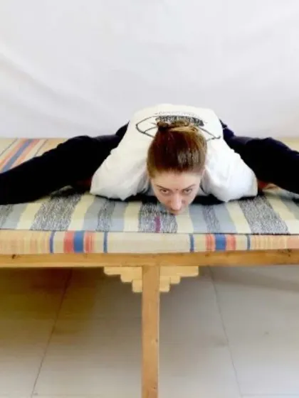 A deep forward bend in Upavistha Konasana (Wide-Angled Seated Forward Bend). This posture stretches the hamstrings and inner thighs while calming the mind.