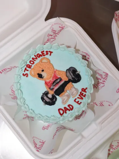 For the "Strongest Dad Ever," this teddy bear lunchbox cake shows a little bear lifting weights. It's a fun and personal way to celebrate him.