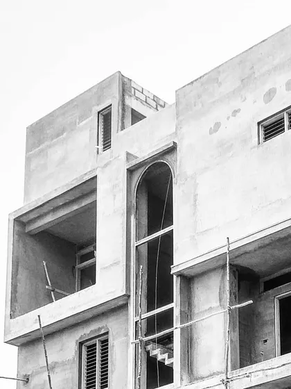A look at the 'Twin Abode' during construction. This black and white photo reveals the home's strong structural bones and the dramatic arch that becomes a key feature of the final design.
