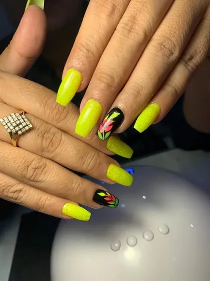A vibrant set of neon yellow nails with hand-painted floral accents.