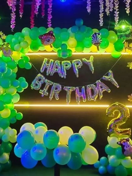 A similar jungle theme with neon lights, perfect for an evening party. The setup includes a "Happy Birthday" foil banner and a number '2' balloon.