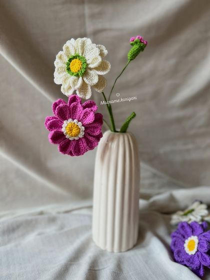 A simple arrangement of pink and white Zianna crochet flowers. Their cheerful, daisy-like appearance is perfect for any decor style.