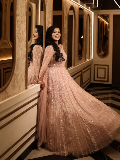 Leaning against a mirror, the bride's reflection adds a beautiful dimension to the photo. Her makeup looks flawless and radiant.
