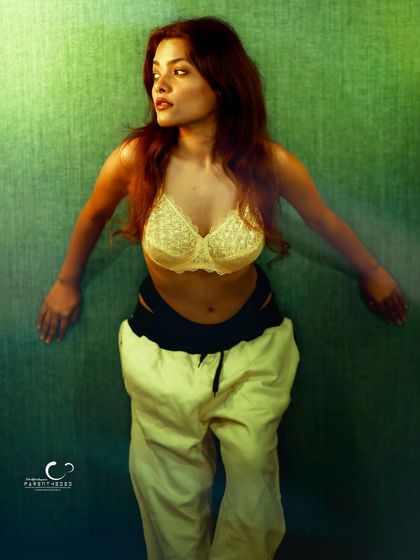 A dynamic pose that feels like a dance. The lighting and her movement create a sense of freedom and artistic expression.