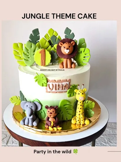 A popular jungle theme cake design, perfect for first birthdays. This one features a lion, elephant, monkey, and giraffe with lush green fondant leaves.