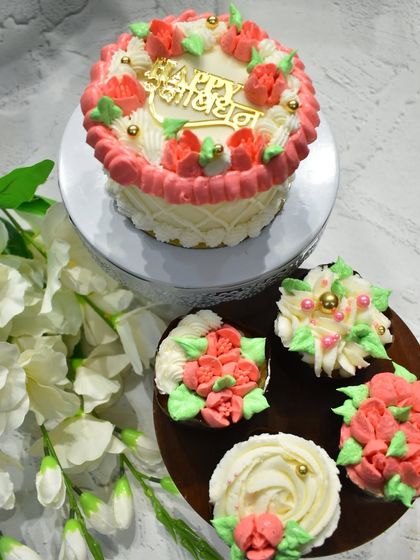 A sweet combo for Raksha Bandhan. This set includes a beautifully decorated chocolate vanilla cake and matching floral pineapple cupcakes in shades of pink and green.