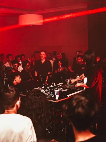 The crowd surrounds the DJ booth, fully engaged with the performance. This 360-degree experience is a signature of our special events.