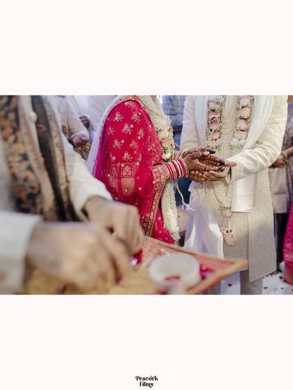 A detail shot of a wedding ritual, capturing the couple's hands as they participate in the ceremony.