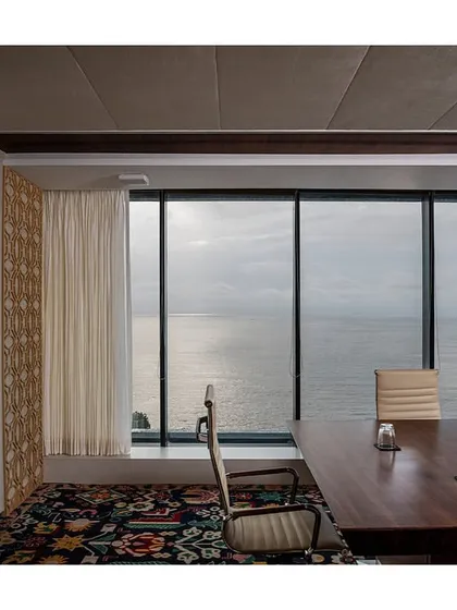 The Taj Boardroom in 'The Office with A View' was designed to align with the brand's regal and traditional identity. The space features a large wood conference table, premium finishes, and a stunning view of the sea, creating an executive meeting environment.