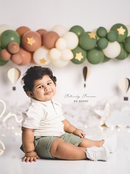A calm and sweet portrait from a hot air balloon themed first birthday. The earthy tones of the balloons create a gentle and soothing atmosphere.