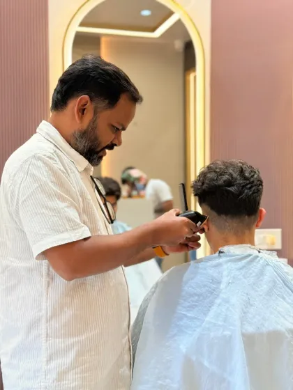 Another shot of a men's haircut in progress. We use both clippers and scissors to achieve the perfect fade and shape.