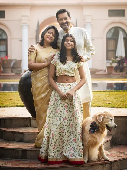 Celebrating 25 years of marriage with the whole family, including their beloved golden retriever. This elegant outdoor portrait captures three generations of love.
