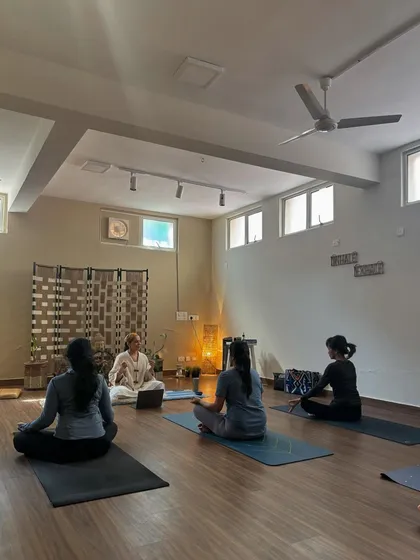 A class beginning in a seated position, preparing for meditation. The calm and focused energy of the shala is palpable.