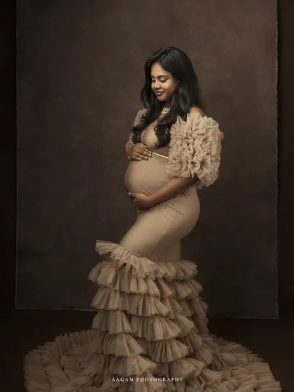 A gentle, downward glance, a hand on her belly. This pose is full of love and quiet contemplation, a mother connecting with her unborn child.