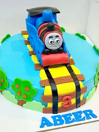 All aboard for a 3rd birthday! This Thomas the Tank Engine cake features a fully handcrafted and edible Thomas on a track, surrounded by fondant trees and scenery.