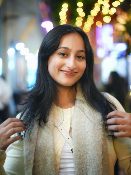 A happy, smiling portrait with beautiful, colorful bokeh. This shot is full of warmth and positive energy, perfect for capturing the lively spirit of the city at night.