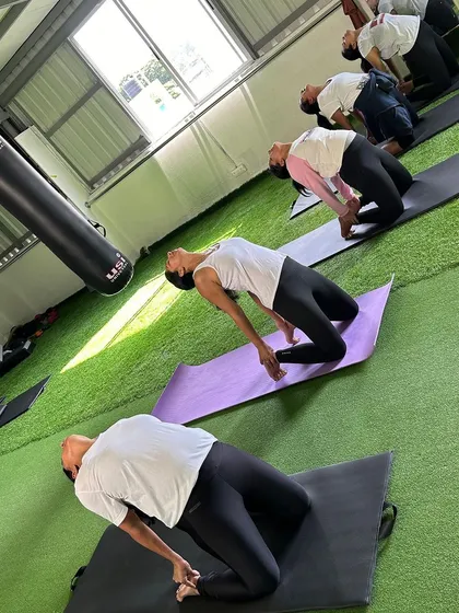 Members practicing the Camel Pose, a deep backbend that opens the chest and improves posture.
