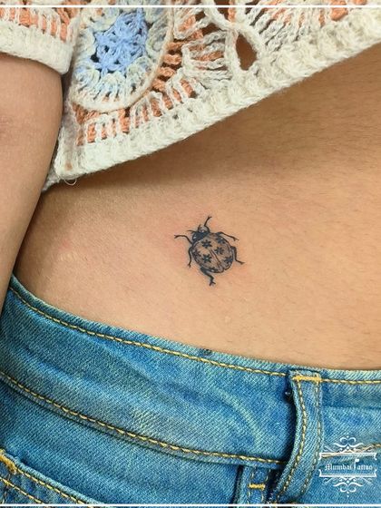 A small ladybug tattoo on the hip, a symbol of good luck. This detailed yet minimal piece shows our ability to capture the essence of nature in a tiny form.