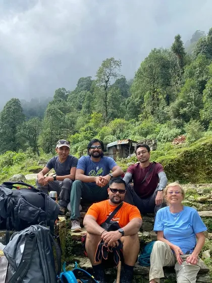 The trekking team resting on ancient stone steps, surrounded by the quiet beauty of the Nepalese wilderness.