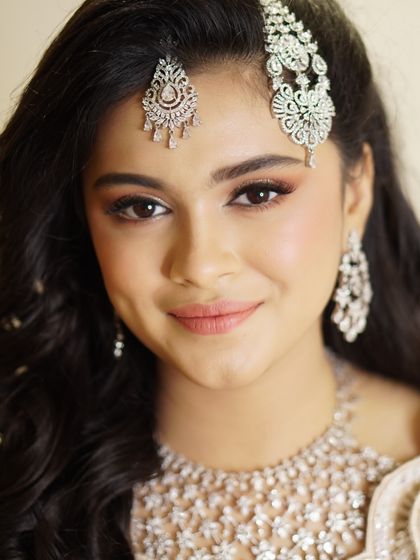 A look of pure elegance. The soft, shimmering eye makeup and flawless skin create a perfect canvas for the stunning diamond jewelry, resulting in a timeless and graceful appearance.
