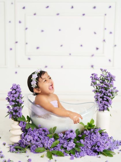 A big, joyful laugh from this little girl in her lavender bath. The falling petals add a touch of magic to this already happy moment.