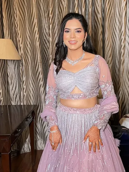 The complete look, showing how the soft makeup and simple hairstyle perfectly complement the intricate details of her engagement outfit.