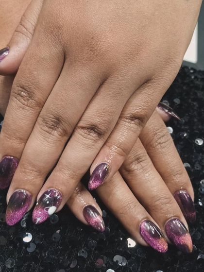 A celestial-inspired cat-eye design. This purple and black magnetic polish is accented with tiny stars and a moon for a truly magical manicure.