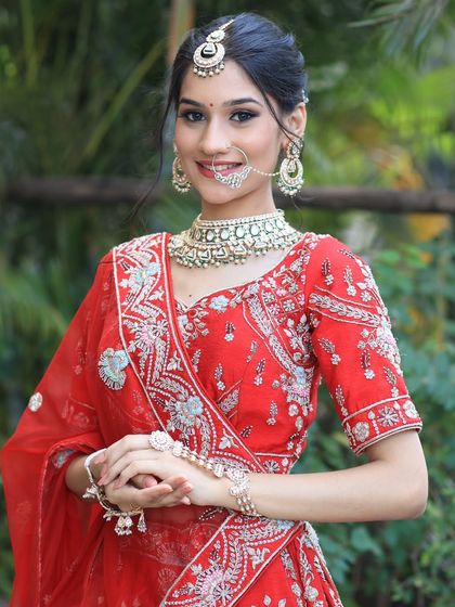 A complete bridal look featuring a heavy, gold-plated Kundan necklace, haath phool, and maang tikka, all available for rent.