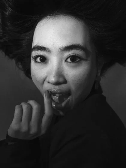 A playful, expressive close-up in black and white. This shot captures the model's personality, providing a dynamic contrast to the more serious, posed shots in the series.