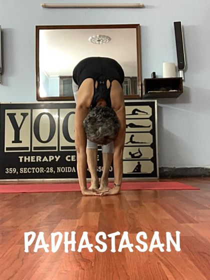 This is another angle of Padahastasana, emphasizing the full spinal release as the head moves towards the legs.