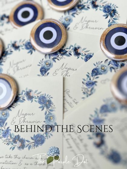 A behind-the-scenes look at the personalized stationery for the Roka. The cards feature a blue floral wreath and evil eye charms, which serve as a token of protection and a thank you to the guests.