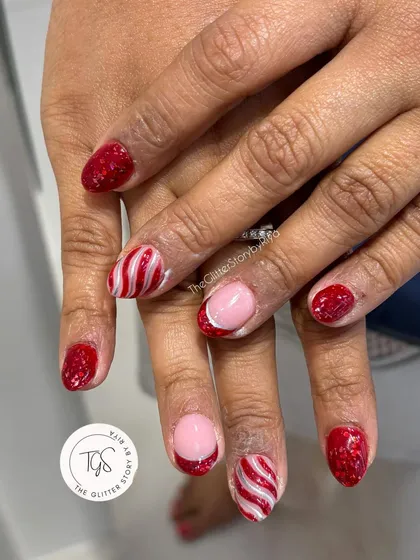 A fun and festive candy cane-inspired manicure. This set features sparkling red glitter nails and accent nails with hand-painted red and white stripes.