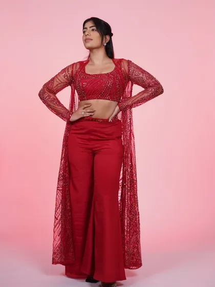 A full-length shot of the red three-piece Indo-Western set, showing its powerful silhouette and sparkling details.