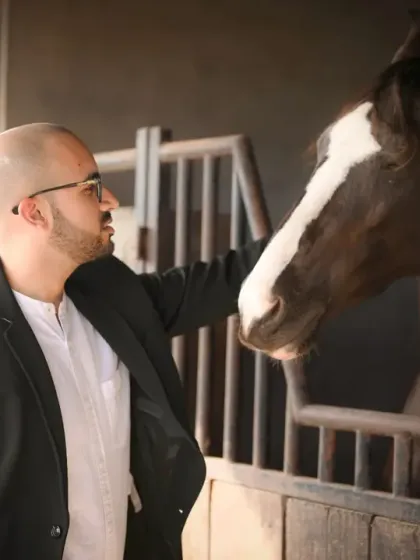 A portrait of the groom-to-be during their pre-wedding shoot. His interaction with the horse showcases a gentle and confident side, adding a unique element to their photo series.