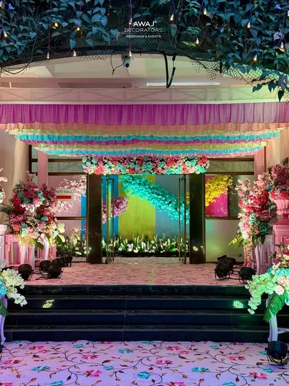 The grand entrance to the hall, with a floral carpet, pastel drapes, and lush arrangements creating a fairytale welcome.