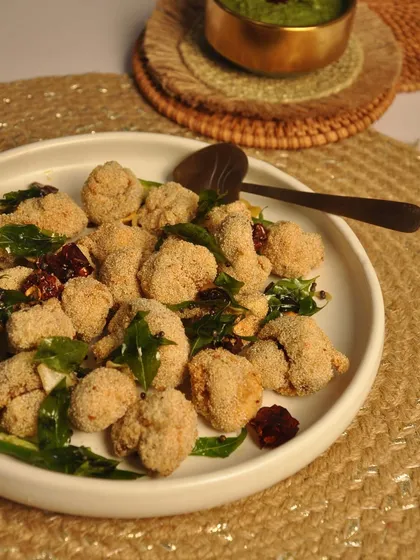 This is my popular Fish Rawa Fry, a classic Goan and Mangalorean preparation. The fish is succulent on the inside and perfectly crispy on the outside, flavored with coconut and coastal spices.