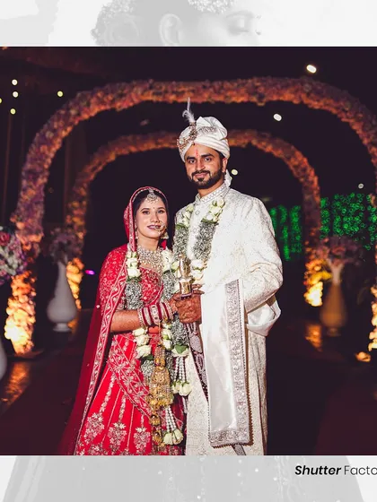 A classic portrait of the newly married couple under a beautifully decorated floral archway. We make sure to get these essential, timeless shots for your wedding album.