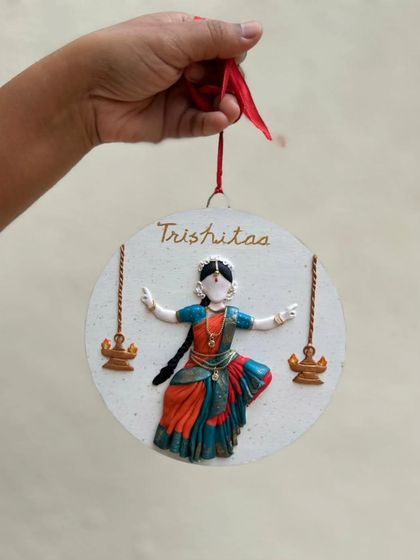 Holding the finished dancer wall plaque. These pieces come with a hook on the back, ready to be hung and admired.