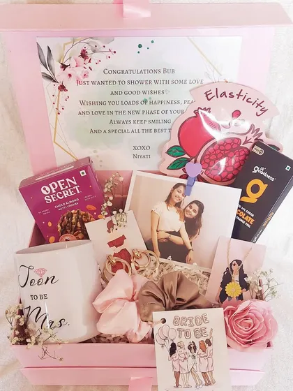 This 'Bride to Be' hamper is all about pampering and love. It's filled with a custom mug, skincare masks, chocolates, and a photo of her and her bestie to remind her of the support she has.