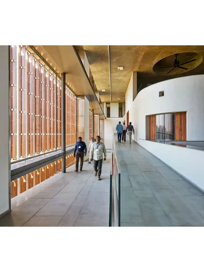 The circulation corridor at the JSW School of Public Policy is animated by the rhythmic pattern of light filtering through the facade's terracotta screens. This space is designed for movement and informal social exchange.