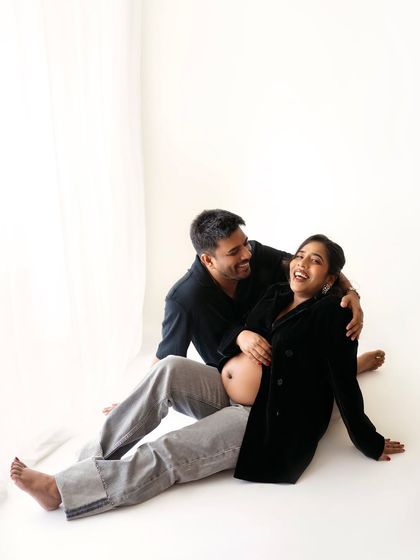 I love these candid, joyful moments during a maternity session. This couple's laughter is infectious, and their relaxed pose makes for an authentic and happy portrait.