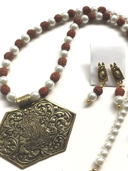 This unisex necklace combines earthy Rudraksha beads with classic pearls and a detailed antique Ganesha pendant. It's a statement piece that can be worn by anyone looking for an ethnic, spiritual accessory.