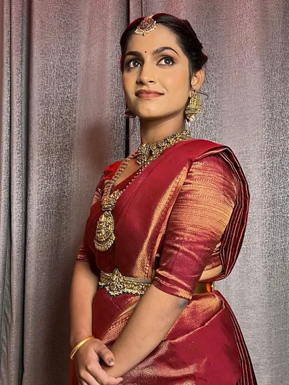 A full view of the elegant bridal look. The simple vaddanam and layered necklaces create a look that is both traditional and understated.