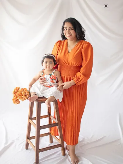 A beautiful mother-daughter photo from a first birthday session. The coordinated orange and white outfits are so bright and cheerful.