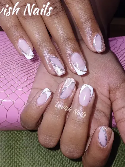 A modern design with abstract white and silver glitter sections at the tips of the nails, creating a broken French manicure effect.
