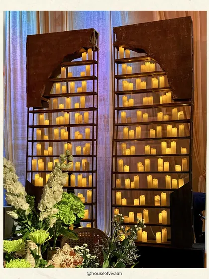Our signature candle walls, featuring hundreds of glowing pillar candles set within arched metal frames, creating a dramatic and romantic backdrop.