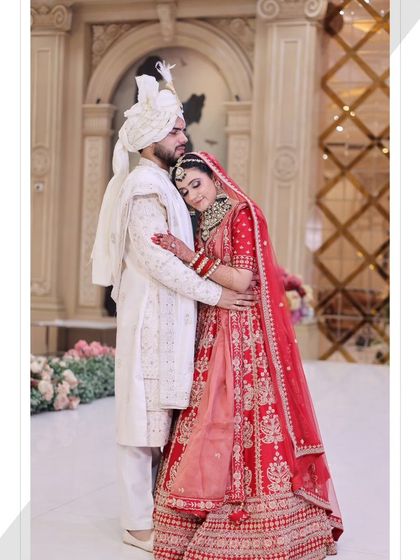 A romantic couple portrait. The bride's makeup is soft and elegant, complementing the groom's white sherwani.
