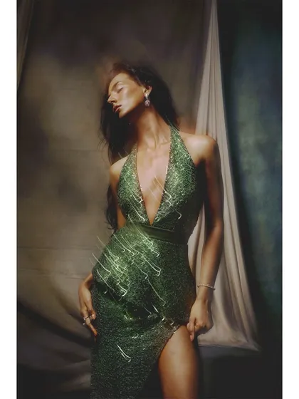 A similar shot of the green gown, but with light streaks that add a magical, energetic quality. This technique helps to emphasize the texture and shine of the sequined material.