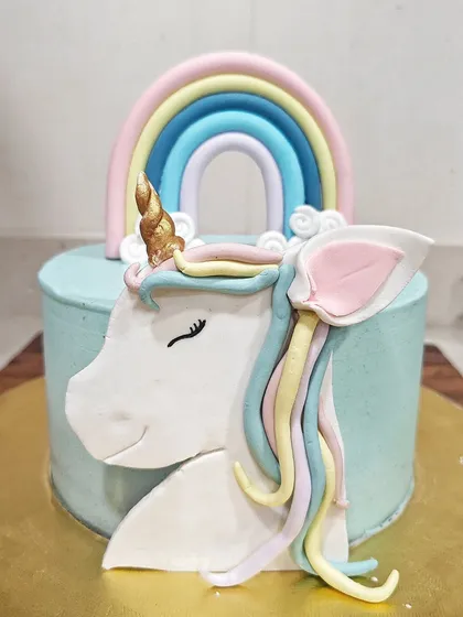 I had so much fun making this adorable unicorn cake. The design features a hand-modeled fondant unicorn with a pastel rainbow mane and a golden horn, set against a soft blue buttercream. It's pure magic for a kid's birthday party.