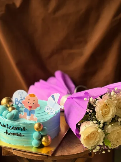 A "Welcome Home" gift set for a new baby boy, including a custom cake and a beautiful bouquet of fresh flowers.